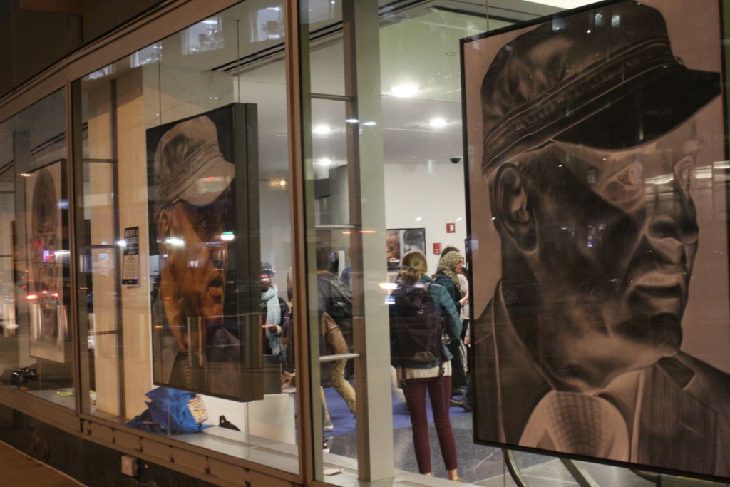 justice through art event, large photos hanging in the windows of the CUNY School of Law